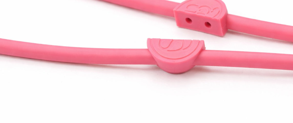 The clasp open: two silicone half-discs, one on each strand of the cord. The upper half shows the two encapsulated magnets
