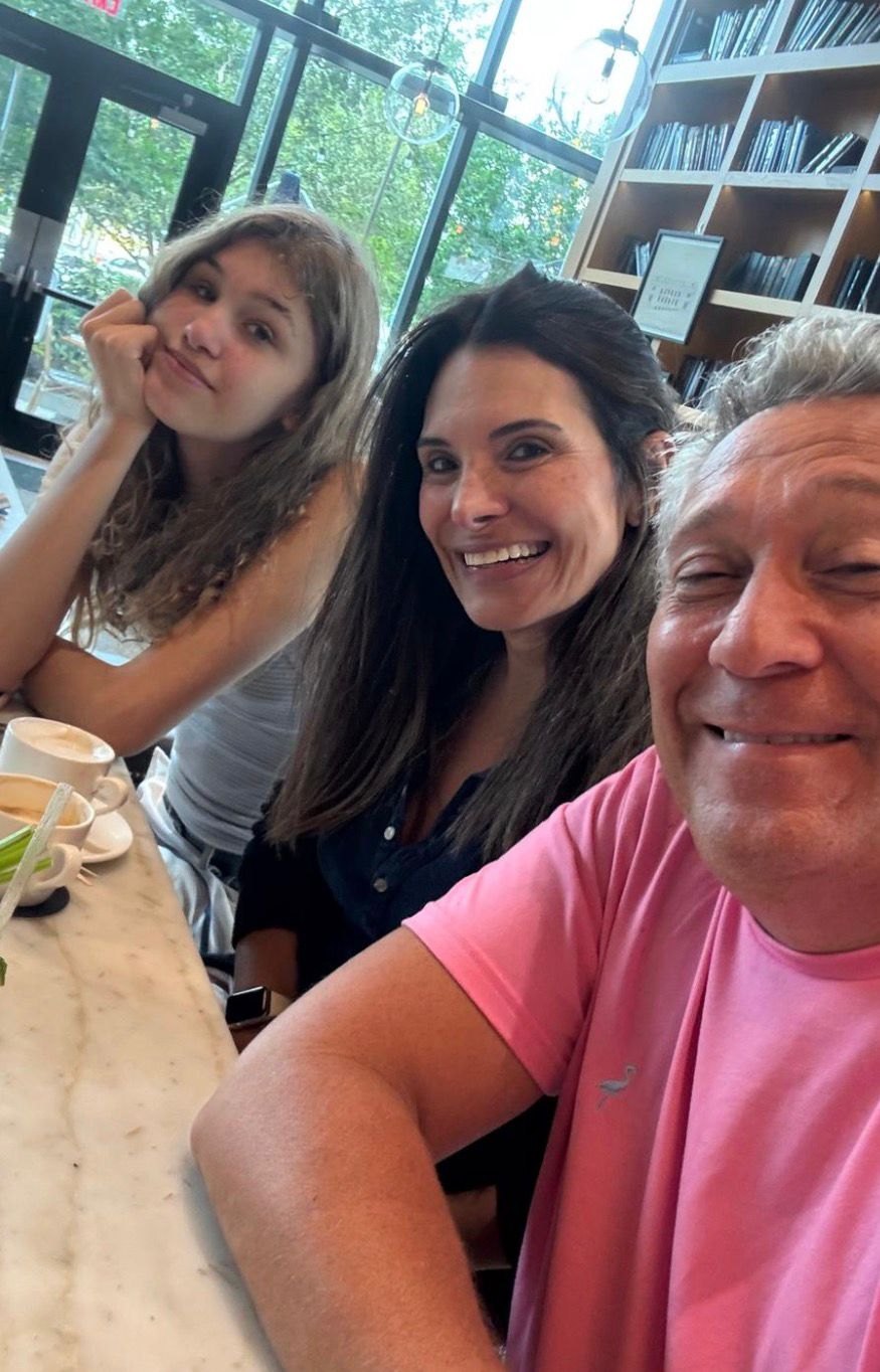 Anabella with her parents at a table